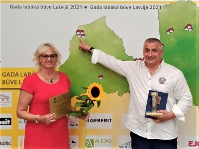 vīrietis un sieviete rokā tur saulespuķi un atzinību