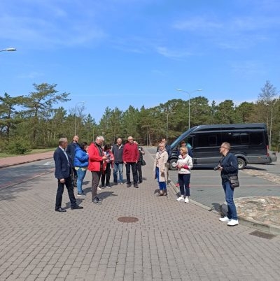 cilvēku bariņš stāv uz ielas